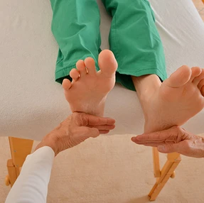 Patient liegt in Rückenlage auf der Liege; Behandlung einer Beinlängendifferenz.