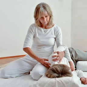 Shiatsu-Behandlung in Seitenlage, Daumendruck gezielt auf den Meridianpunkt Dünndarm 11.